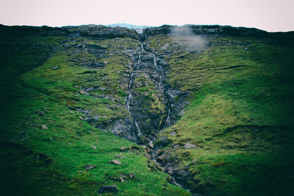 Ein Wasserfall, der einen Berghang hinunterfließt.
