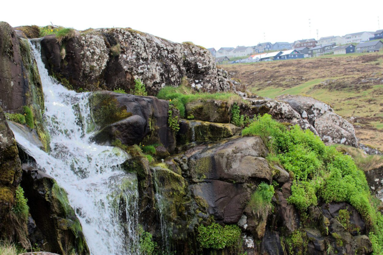 Ein Wasserfall auf einem felsigen Hügel.
