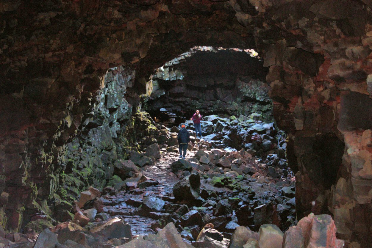 Eine Gruppe von Menschen geht durch eine Höhle.