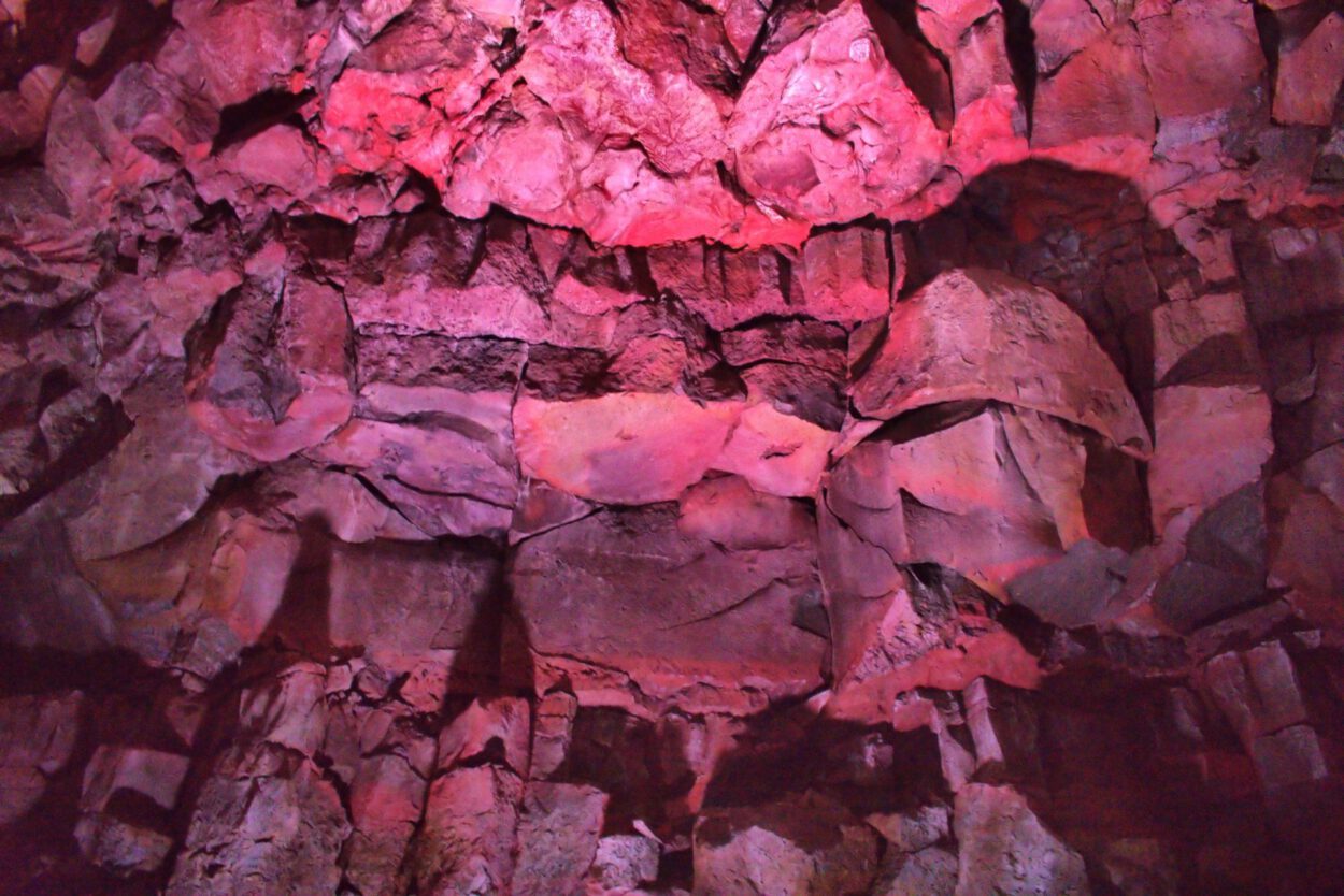 Das Innere einer Höhle ist mit roten Lichtern beleuchtet.