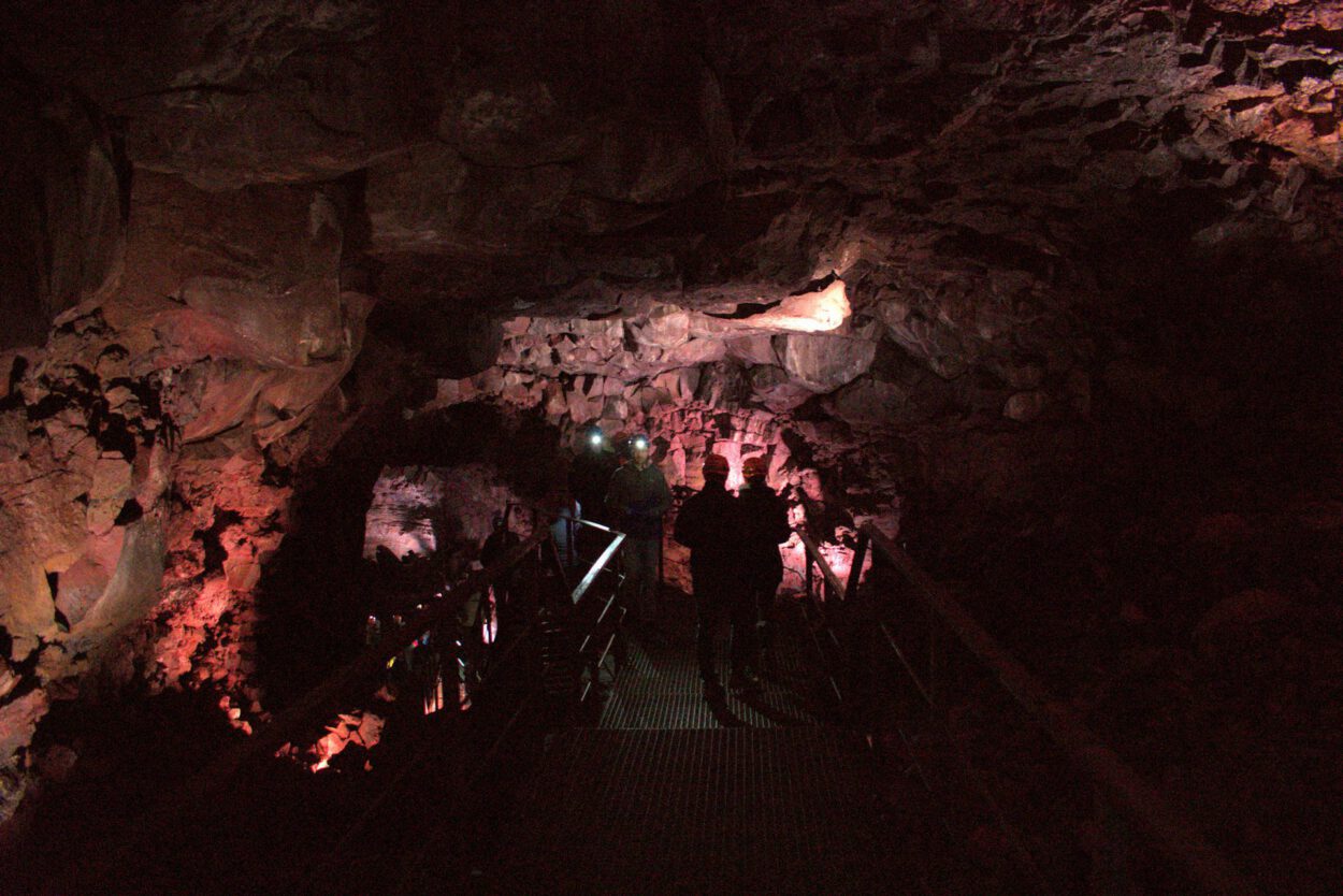 Eine Gruppe von Menschen geht durch eine Höhle.