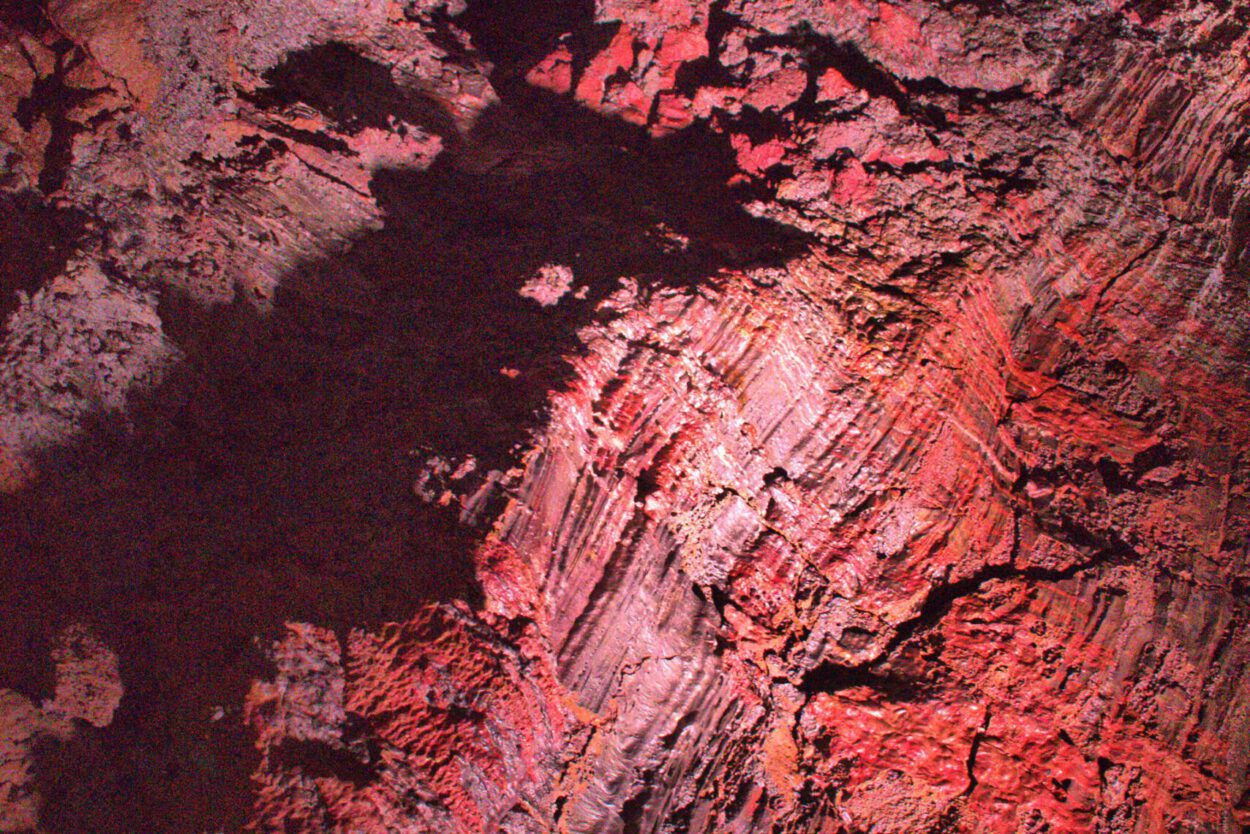 Ein rotes Licht scheint auf einen Felsen in einer Höhle.