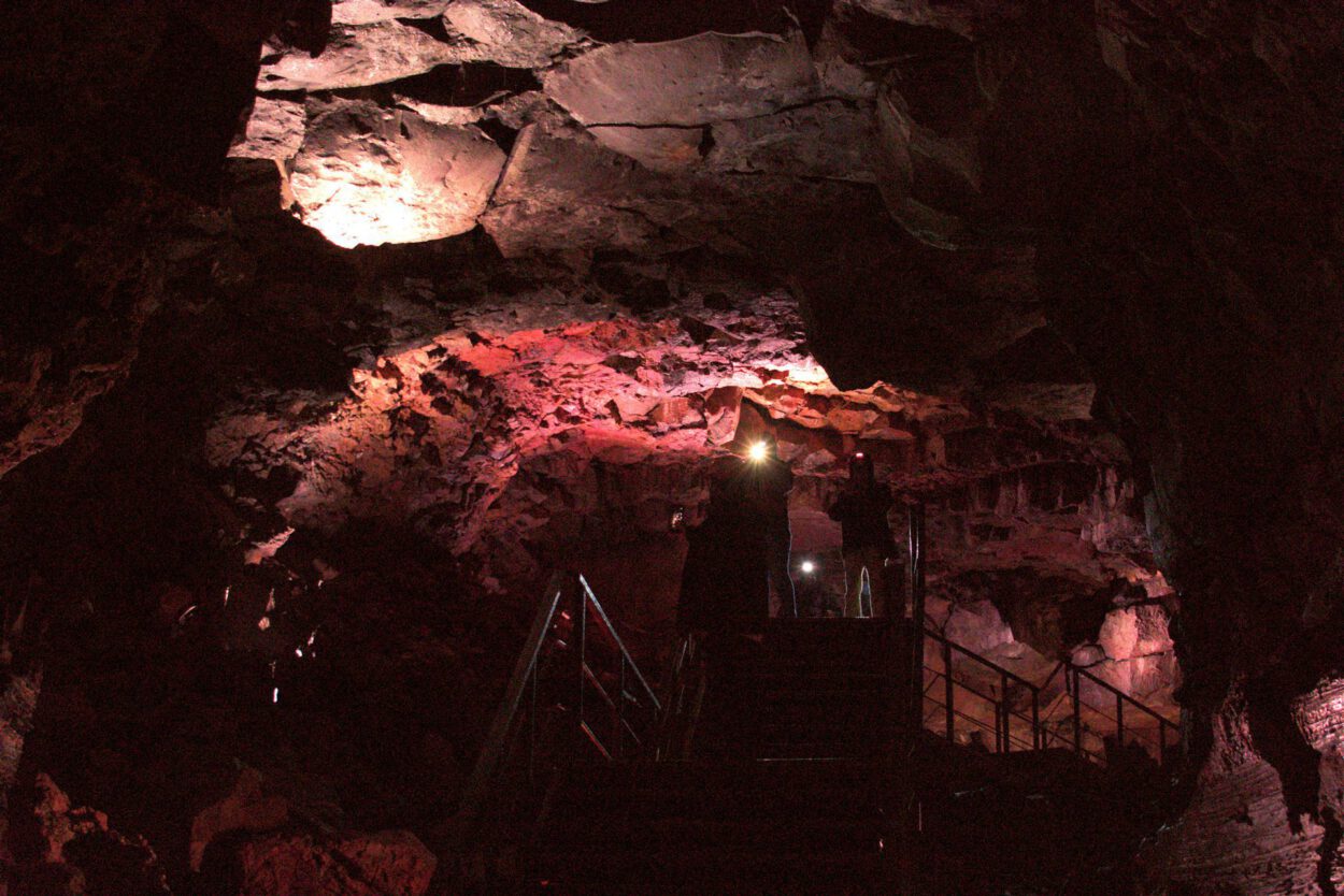 Eine Treppe führt hinauf zu einer Höhle.