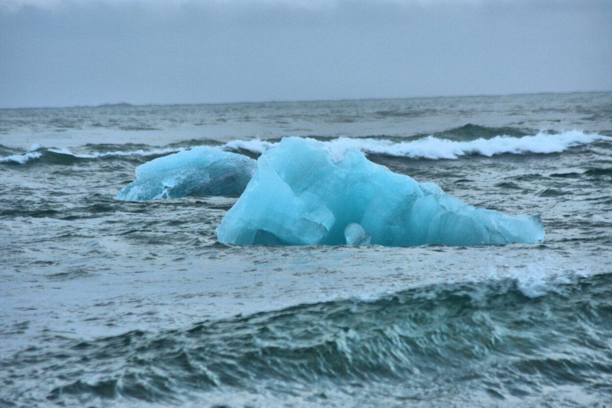 Zwei blaue Eisberge schwimmen im Ozean.