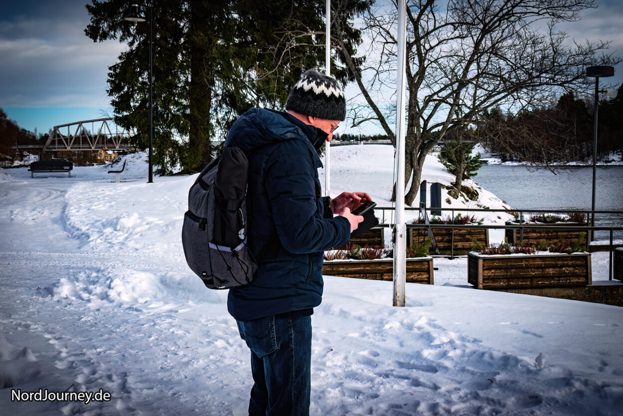 Ein Mann steht mit einem Rucksack im Schnee.