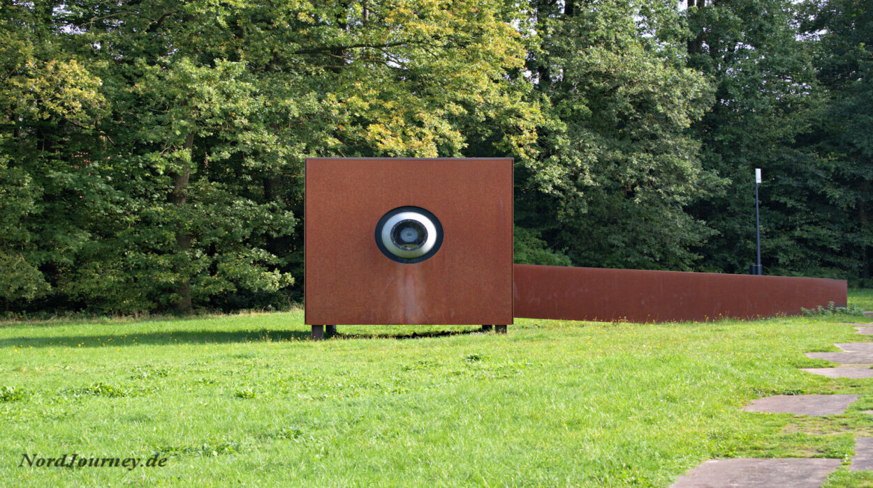 Eine rote Skulptur inmitten einer Wiese.