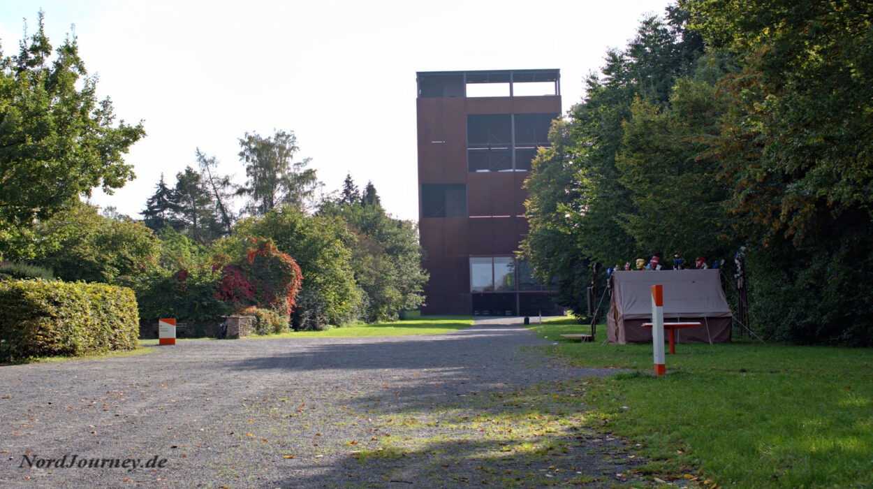 Ein großes Gebäude mit einem Glockenturm inmitten eines Feldes.